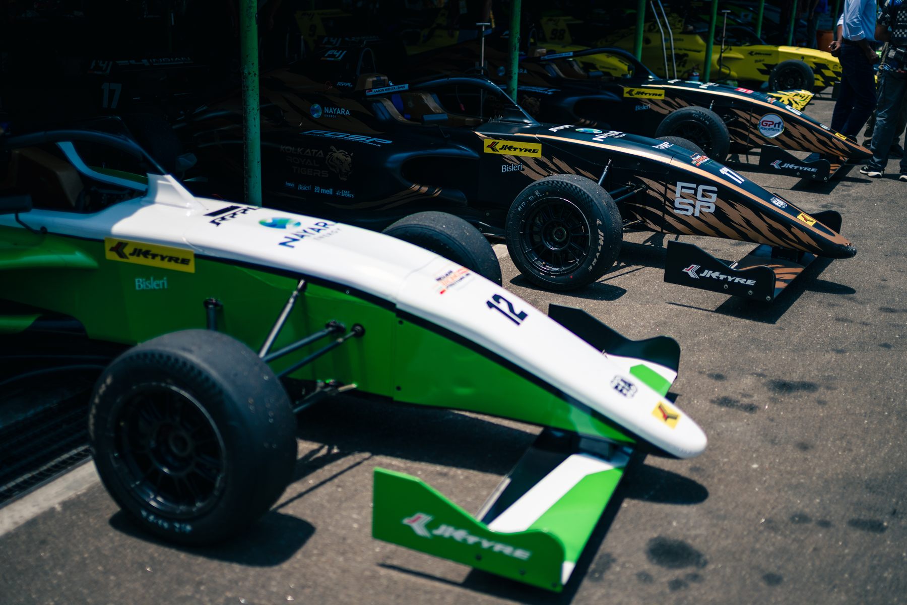 Formula 4-biler oppstilt på rekke i paddocken